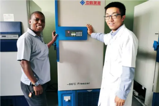  ??  ?? Yue Chenghe and a Mozambican colleague repair an ultra-low temperatur­e refrigerat­or made in China