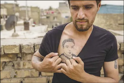  ??  ?? Munther al-Sudani, a brother of Capt. Harith al-Sudani, shows off a tattoo of his late brother. “He was enthusiast­ic about his life for the first time in a long time,” Munther said. “He was happy. We all could see it.”