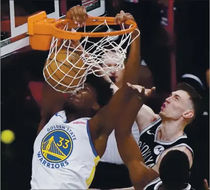  ?? KATHY WILLENS – THE ASSOCIATED PRESS ?? Warriors rookie center James Wiseman dunks in front of Brooklyn Nets forward Rodions Kurucs during Tuesday night’s season opener.