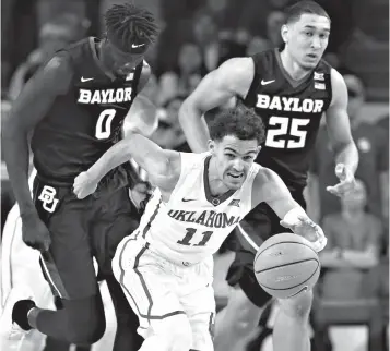  ?? Associated Press ?? ■ In this Jan. 30 file photo, Oklahoma guard Trae Young (11) heads up the court with a steal in front of Baylor forwards Jo Lual-Acuil Jr. (0) and Tristan Clark (25) during the second half of an NCAA college basketball game in Norman, Okla. About a...