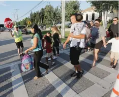  ?? OCTAVIO JONES/TAMPA BAY TIMES/AP ?? Students arrive with parents and guardians for the first day of school at Bay Crest Elementary in Tampa, Fla. on Thursday, Aug. 10.