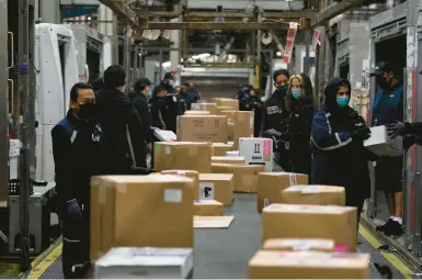  ?? JAE C. HONG/AP 2021 ?? Employees sort packages for delivery at the FedEx regional hub at the Los Angeles Internatio­nal Airport.