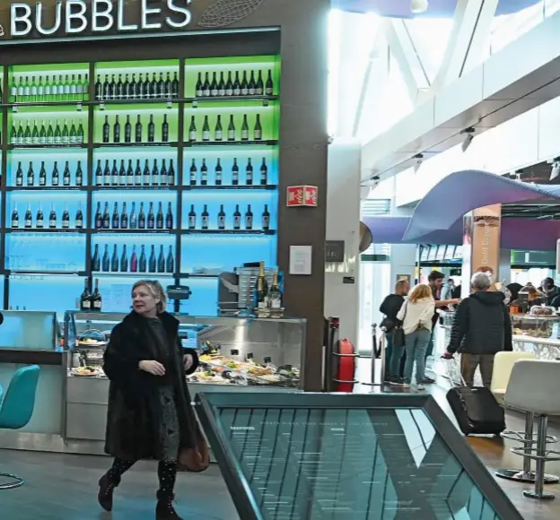  ??  ?? Al Bubbles Seafood & Wine Bar, nell’aeroporto Schiphol di Amsterdam, si sorseggia champagne davanti a un grande acquario e una parete di bottiglie.