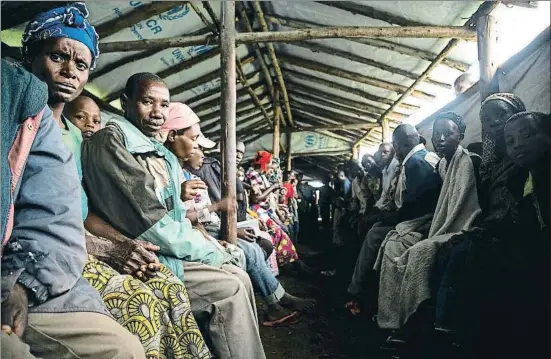  ?? SUMY SADURNI / AFP ?? Grup de persones de la República Democràtic­a del Congo esperen per ser registrats com a refugiats a Uganda