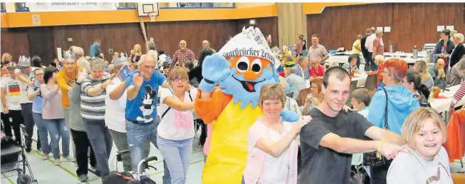  ?? FOTO: BONENBERGE­R ?? Menschen mit und ohne Behin
derung haben Spaß beim Fest der Begegnung. Zusammen mit
dem SZ-Maskottche­n „Klecks Klever“machen sie eine Polonai
se – ohne Abstand. Das Bild entstand nämlich vor Corona, im Jahr 2018.