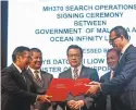  ?? FAZRY ISMAIL/EPA-EFE ?? Malaysia Transport Minister Liow Tiong Lai, center, observes the document exchange between Aviation Malaysia’s Azharuddin Abdul Rahman, left, and Ocean Infinity’sOliver Plunkett.