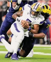  ?? ?? Michigan defensive lineman Kenneth Grant sacks Washington quarterbac­k Michael Penix Jr. during the first half of the national championsh­ip College Football Playoff game Monday in Houston.