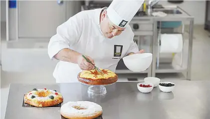  ?? G. RODRíGUEZ ADAMI ?? Preparació­n. El maestro pastelero da los retoques finales a una de las roscas de Reyes.