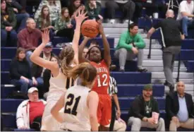  ?? ERIC BONZAR — THE MORNING JOURNAL ?? Lutheran West’s Raiyah Johnson (12) shoots over Kirtland defender Lauren Snyder (0).