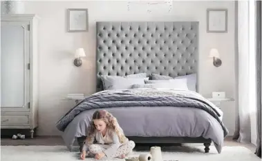  ?? RH BABY AND CHILD/AP Photo ?? A tufted headboard, soft, gentle colours and an interestin­g version of a chandelier created a spacethat is girlie yet sophistica­ted in this child’s bedroom.