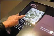  ?? ?? World War II veteran Olin Pickens, of Nesbit, Miss., who served in the U.S. Army 805th Tank Destroyer Battalion, looks at a photo of himself as a 120-pound prisoner of war Wednesday at the National World War II Museum in New Orleans.