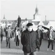  ?? PETR DAVID JOSEK/AP ?? The Czech Republic last week had a record 8,500 people hospitaliz­ed with COVID-19. Above, a man walks across the Charles Bridge on Feb. 25 in Prague.