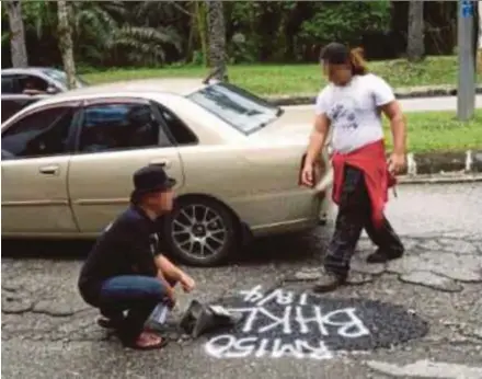  ?? FILE PIC ?? The actor (left) next to a pothole at Port Dickson that he repaired in April. He was arrested after chaining and locking the gate of the Petaling District and Land Office in Section U5 here on Thursday.