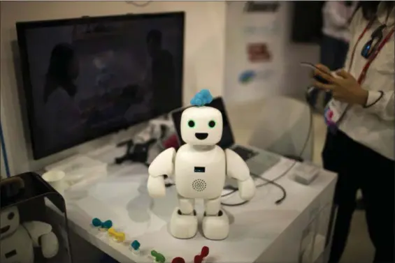  ?? EMILIO MORENATTI — THE ASSOCIATED PRESS ?? Pibo robot, whose main purpose is getting you and your loved ones sharing your daily life again, receives instructio­ns from her owner, at the Four Years From Now (FYFN) show, a sidebar event of Mobile World Congress in Barcelona, Spain, Monday.