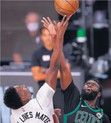  ??  ?? Bam Adebayo y Jaylen Brown saltan en una lucha por el balón durante el quinto partido de la serie.