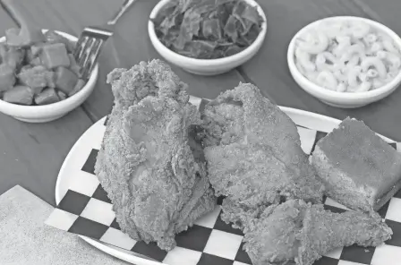  ?? TIM JOHNSON PHOTOS/COLUMBUS MONTHLY ?? Fried chicken dinner with greens, mac-and-cheese and yams at Modern Southern Table in the Budd Dairy Food Hall.