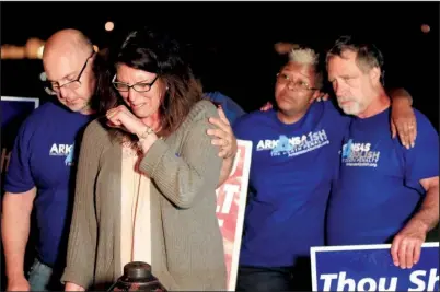  ?? Arkansas Democrat- Gazette/ STATON BREIDENTHA­L ?? Abe Bonowitz comforts Lynn Scott ( second from left) outside the Cummins Unit during a vigil with Judy Johnson, Randy Gardner and other protesters shortly after all of the stays for Ledell Lee’s execution were exhausted late Thursday.