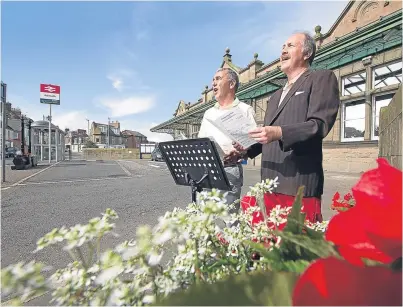 ?? Picture: Paul Reid. ?? Steve Cargill and Richard Irvine entertain passersby at Arbroath Railway Station.
