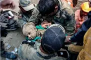  ?? PTI ?? A rescuer holds infant Nadeem fter an operation to rescue him from inside a 60-feet-deep borewell where he fell while playing near his house in Balsamand village. —