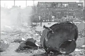  ?? Oleksandr Gimanov/afp/getty Images ?? A man walks past fragments of missiles in front of the shopping and entertainm­ent center in the Ukrainian Black Sea city of Odessa on Tuesday, destroyed after Russian missiles strike late Monday.