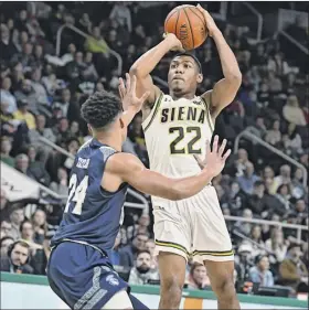  ?? Lori Van Buren / times union ?? Siena’s freshman star Jalen Pickett shoots a 3-pointer against Saint Peter’s Quinn taylor on tuesday night at times union Center in Albany.