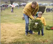  ?? LAUREN A. LITTLE — MEDIANEWS GROUP ?? Thomas Ashman of Cumru Township helps his son, Owen, age 3, lay a wreath during Wreaths Across America at Forest Hills Memorial Park.