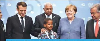  ??  ?? Frank Bainimaram­a, Prime Minister of Fiji and President of COP 23, French President Emmanuel Macron, German Chancellor Angela Merkel and UN Secretary-General Antonio Guterres pose with a young Fijian boy at the UN conference on climate change (COP23) on Nov 15, 2017 in Bonn. —AFP