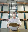  ?? TED S. WARREN/AP ?? Micah Truman, CEO of Return Home, a company that composts human remains into soil, holds a container of soil made with animal remains that is used to show what the product of their process looks like.
