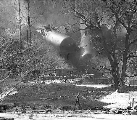  ?? Chris Tile y/the asociated pres ?? Crew members walk near the scene of a train derailment near Mount Carbon, W.Va. in February. Rail tank
cars that are used to transport most crude oil and many other flammable liquids will have to be built to stronger standards to reduce the risk of...