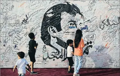  ?? NASEEM ZEITOON / REUTERS ?? Uns nens passen per davant d’una retrat de l’emir Tamim bin Hamad al-Thani pintat a Doha