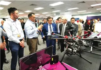  ??  ?? Abang Johari (third left) looks at a drone on display.