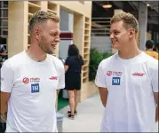  ?? DARRON CUMMINGS/AP ?? Kevin Magnussen (left) of Denmark, who is back after vowing never to return to F1, chats with fellow Haas driver Mick Schumacher of Germany during the walk-through before today’s race in Miami.