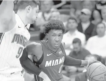  ?? MIKE STOCKER/SUN SENTINEL ?? Heat guard Josh Richardson attempts to drive around Magic center Nikola Vucevic during Tuesday night’s game.