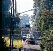  ?? HYOSUB SHIN / HSHIN@AJC.COM ?? Crews work to restore power on Britt Drive in Snellville on Wednesday. Some 347,000 Georgia Power customers were in the dark at noon, according to the Atlanta utility’s statewide outage map. About 128,000 of those were in the metro Atlanta counties of...