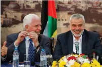  ?? (Suhaib Salem/Reuters) ?? SENIOR FATAH official Azzam Al-Ahmed (left) and the head of the Hamas government Ismail Haniyeh attend a news conference in Gaza City in 2014.