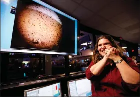  ?? Al Seib/AP ?? Success: An engineer smiles next to an image of Mars sent from the InSight lander shortly after it landed on Mars in the mission support area of the space flight operation facility at NASA's Jet Propulsion Laboratory Monday in Pasadena, Calif.