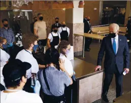  ?? EVAN VUCCI — THE ASSOCIATED PRESS ?? President Joe Biden talks with staff during a visit to Taqueria Las Gemelas restaurant in Washington, D.C., on Wednesday.