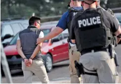  ??  ?? A man is taken into custody Wednesday at a Koch Foods Inc. plant in Morton, Miss. U.S. immigratio­n officials raided several Mississipp­i food processing plants.