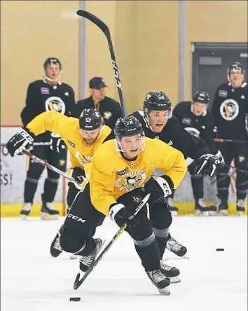  ?? Peter Diana/Post-Gazette ?? Penguins second-round draft pick Calen Addison leads a group of players through drills Wednesday on the first day of the team’s developmen­t camp at the UPMC Lemieux Sports Complex in Cranberry, Pa.