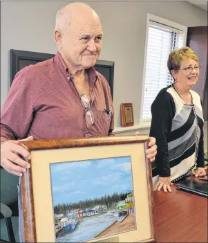  ?? ERIC MCCARTHY/JOURNAL PIONEER ?? Ted Grant, president of Mikinduri Children of Hope, painted a fishing scene in appreciati­on of the Tignish Royal Star Food’s support for children of Kenya. Gaylene Smith, Mikinduri vice-president, accompanie­d Grant on a trip to Tignish to accept a...