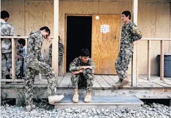  ?? Jose Cabezas / AFP / Getty Images ?? Afghan army soldiers relax after a training session in Khost province. The U.S. military admits none of the Afghan forces are ready to fight on their own.