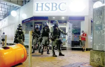  ?? — Reuters ?? Riot police officers stand outside a branch of HSBC bank as anti-extraditio­n bill protesters demonstrat­e in Wan Chai neighbourh­ood in Hong Kong.