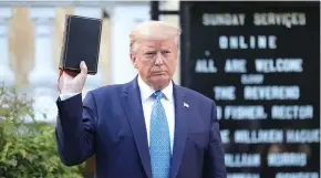  ??  ?? U.S. President Donald Trump holds up a Bible as he stands in front of St. John’s Episcopal Church across from the White House.