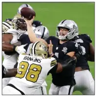  ?? (AP/Isaac Brekken) ?? Las Vegas Raiders quarterbac­k Derek Carr (right) passes over New Orleans Saints defensive tackle Sheldon Rankins (98) during the first half Monday in Las Vegas. Carr threw for 282 yards and 3 touchdowns in a 34-24 victory for the Raiders.