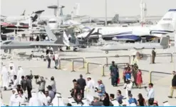  ??  ?? DUBAI: Participan­ts walk past drones displayed during the Dubai Air Show yesterday.