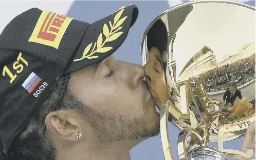  ??  ?? 0 Lewis Hamilton kisses the trophy in Russia after stretching his F1 championsh­ip lead to 73 points with just 130 remaining.