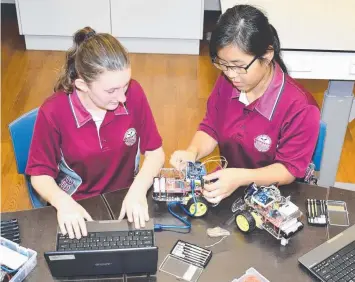  ??  ?? Woree State High School students Josephine Austin and Felicity Ly (Year 9) programmin­g their robotics projects using Arduino.