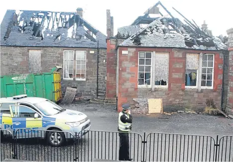  ??  ?? Police within the grounds of the former Wellbrae Primary School today, where the damage to the roof is visible.