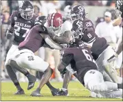  ?? SAM CRAFT — THE ASSOCIATED PRESS ?? Alabama wide receiver John Metchie III, center, is brought down by the Texas A&M defense during Saturday night’s game in which the unranked Aggies surprised the No. 1 Crimson Tide 41-38 on a field goal as time expired.