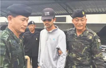  ?? National Council for Peace and Order ?? Thai authoritie­s accompany a man they believe is part of a group responsibl­e for a deadly bombing last month at a shrine in Bangkok. He was detained near the Cambodian border.